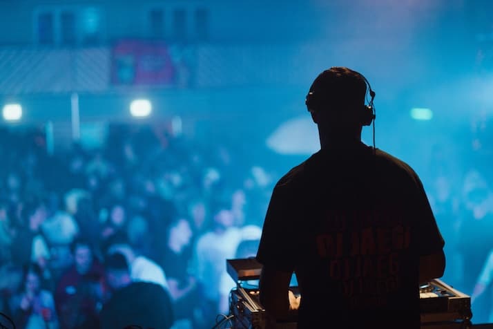DJ mixing in a neon-lit booth